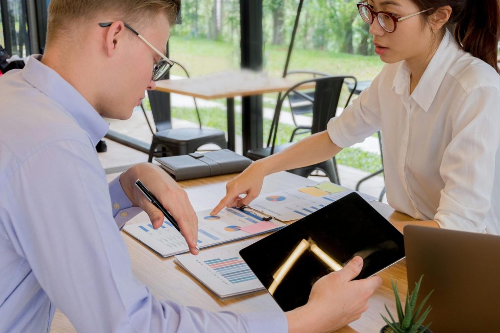 Collaboration d'équipe autour de documents financiers dans un environnement de bureau moderne.