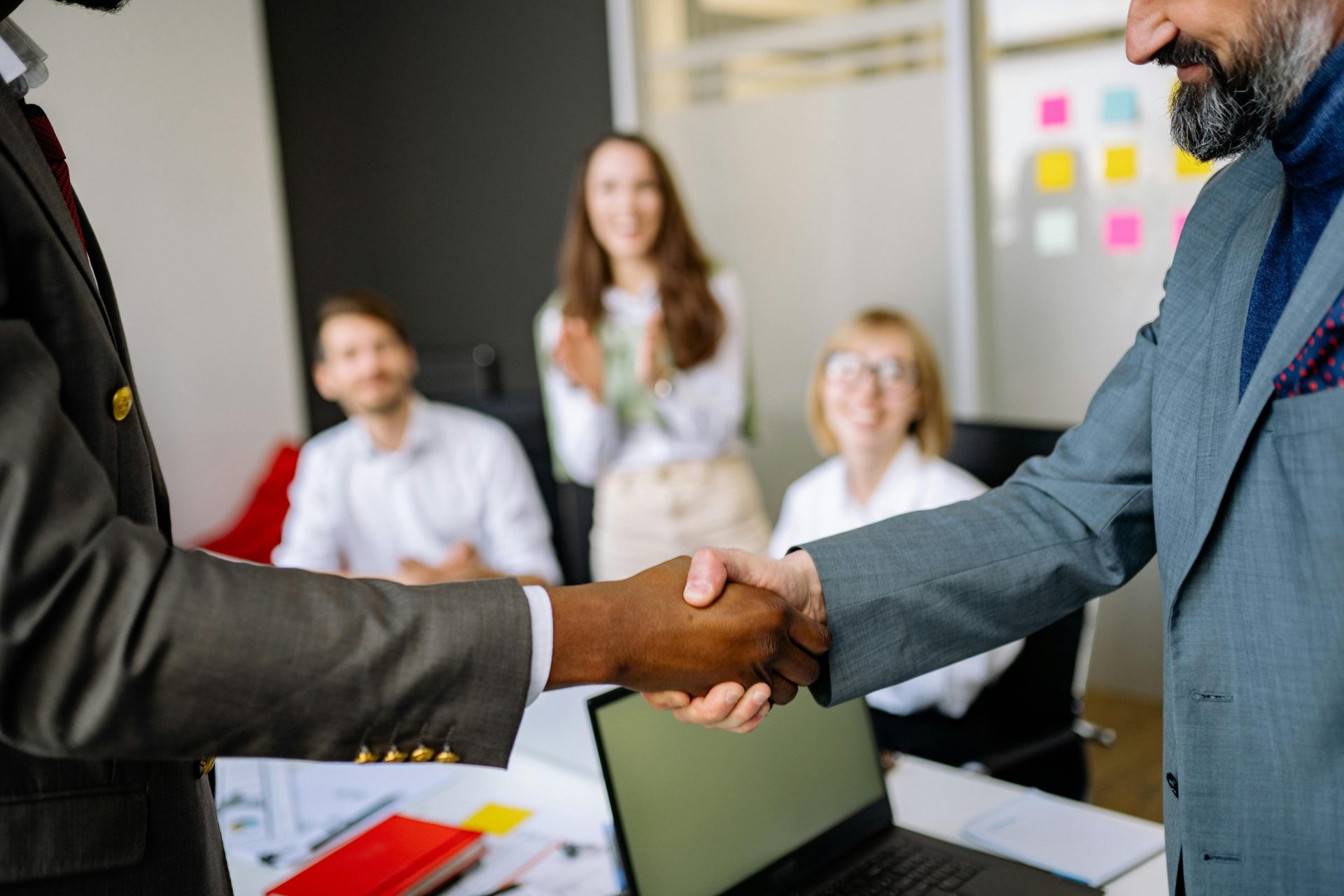 Gros plan sur une poignée de main entre collègues, dans un cadre de bureau professionnel, mettant l'accent sur le travail d'équipe et l'accord mutuel.