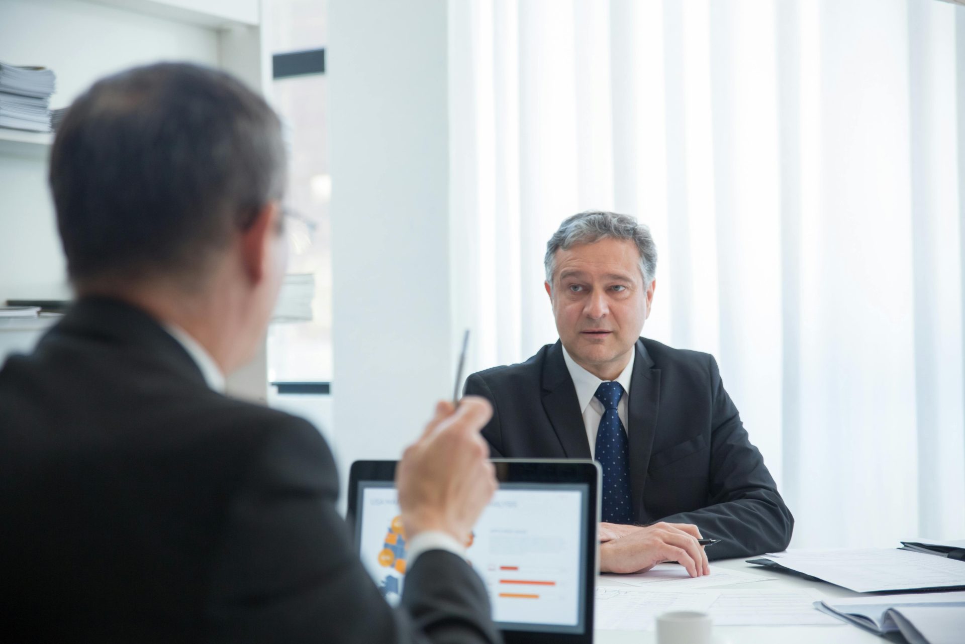 Des professionnels en pleine discussion concentrée lors d'une réunion de bureau.