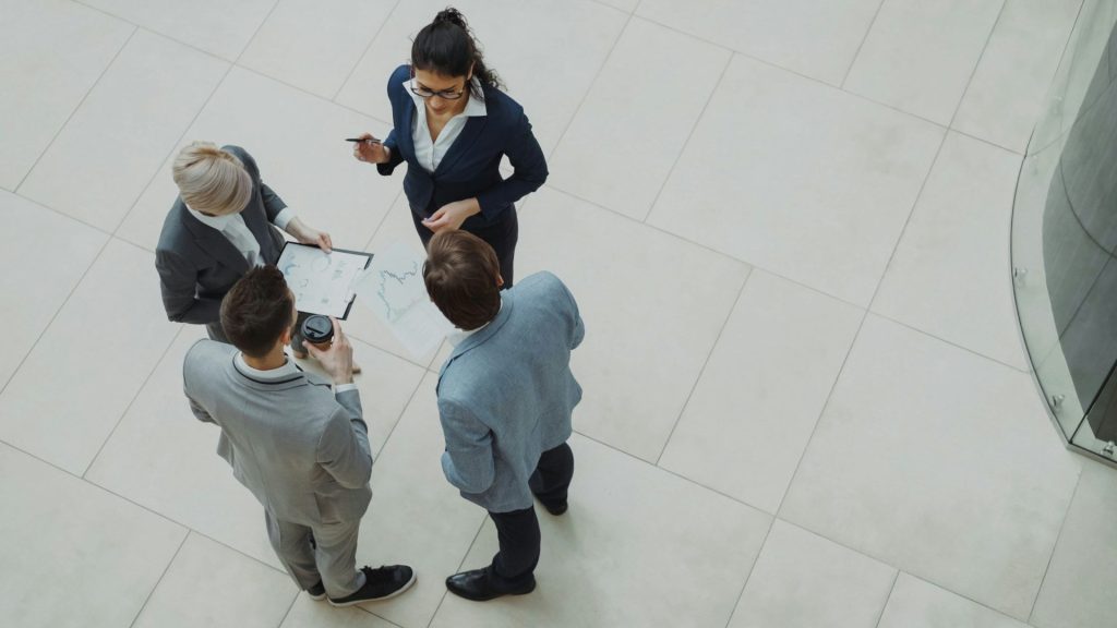 Four business professionals collaborating in a modern office space.